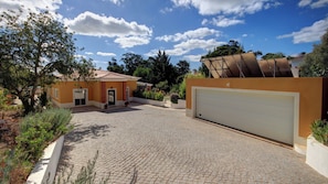 Una propiedad residencial con entrada pavimentada, garaje y jardín.