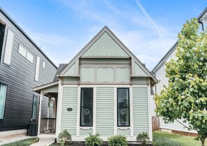 A two-story house with a gabled roof, a front porch, and a small front yard. - Cute Fountain Square Cottage-sleeps 4 (Indianapolis)