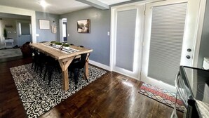A dining area with a wooden table, chairs, and a patterned rug. - Wolf River Getaway-close to dock (Highway)