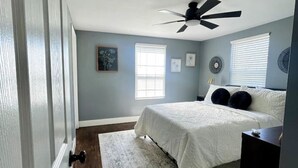 A bedroom with a bed, a ceiling fan, a rug, and a window. - Wolf River Getaway-close to dock (Highway)