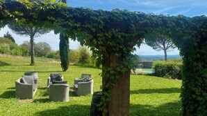 Un patio con una mesa de mosaico, mobiliario de mimbre y vistas al paisaje.
