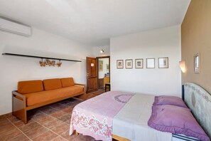 Un dormitori amb un llit, un sofà i una paret amb quadres.