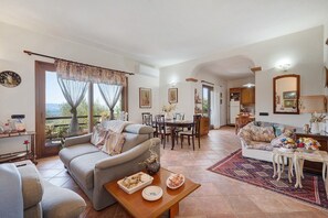Una sala de estar amplia con un sofá, una mesa de comedor y una cocina al fondo.
