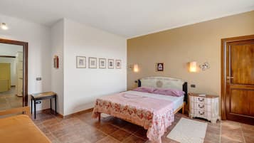 Une chambre à coucher comprenant un lit, des tables de chevet, une commode, un miroir et des tableaux encadrés accrochés au mur.