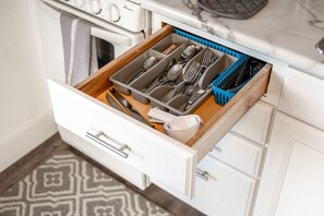 A kitchen drawer with utensils and a blue basket. - Entire unit-Close to Lucas Oil! (Indianapolis)