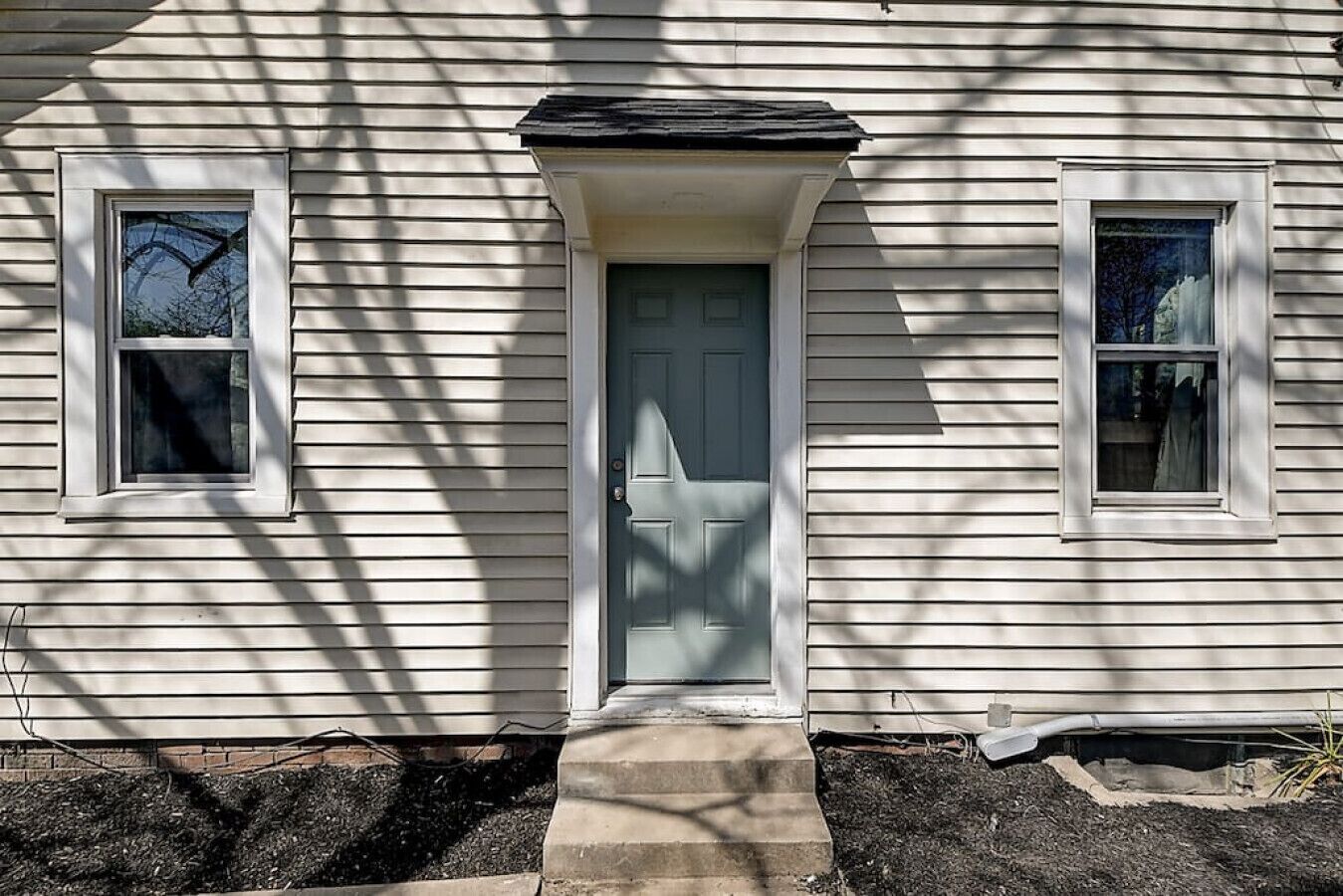 A house with a front door, two windows, and a small porch.