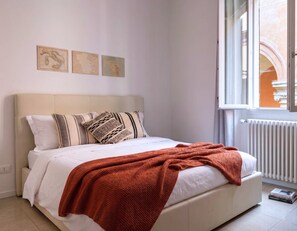A bedroom with a bed, pillows, a window, and a radiator. - Casa Accademia in the Heart of Bologna (Bologna)