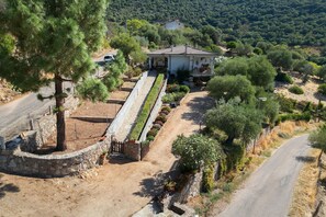 Una propiedad rural con un camino de piedra que lleva a una casa con techo de tejas.