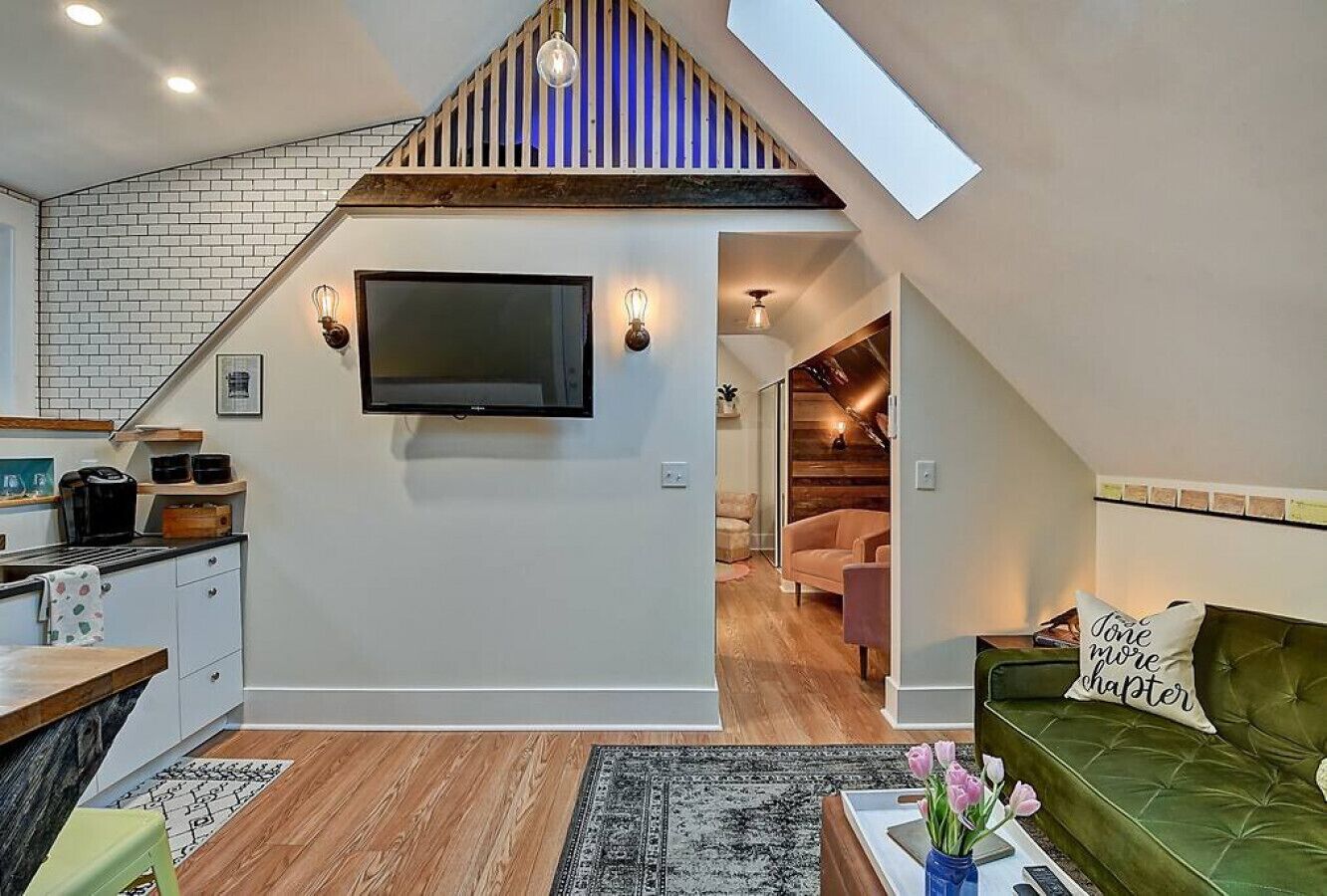 Un loft moderno con cocina, sala de estar y una escalera que lleva a un nivel superior.