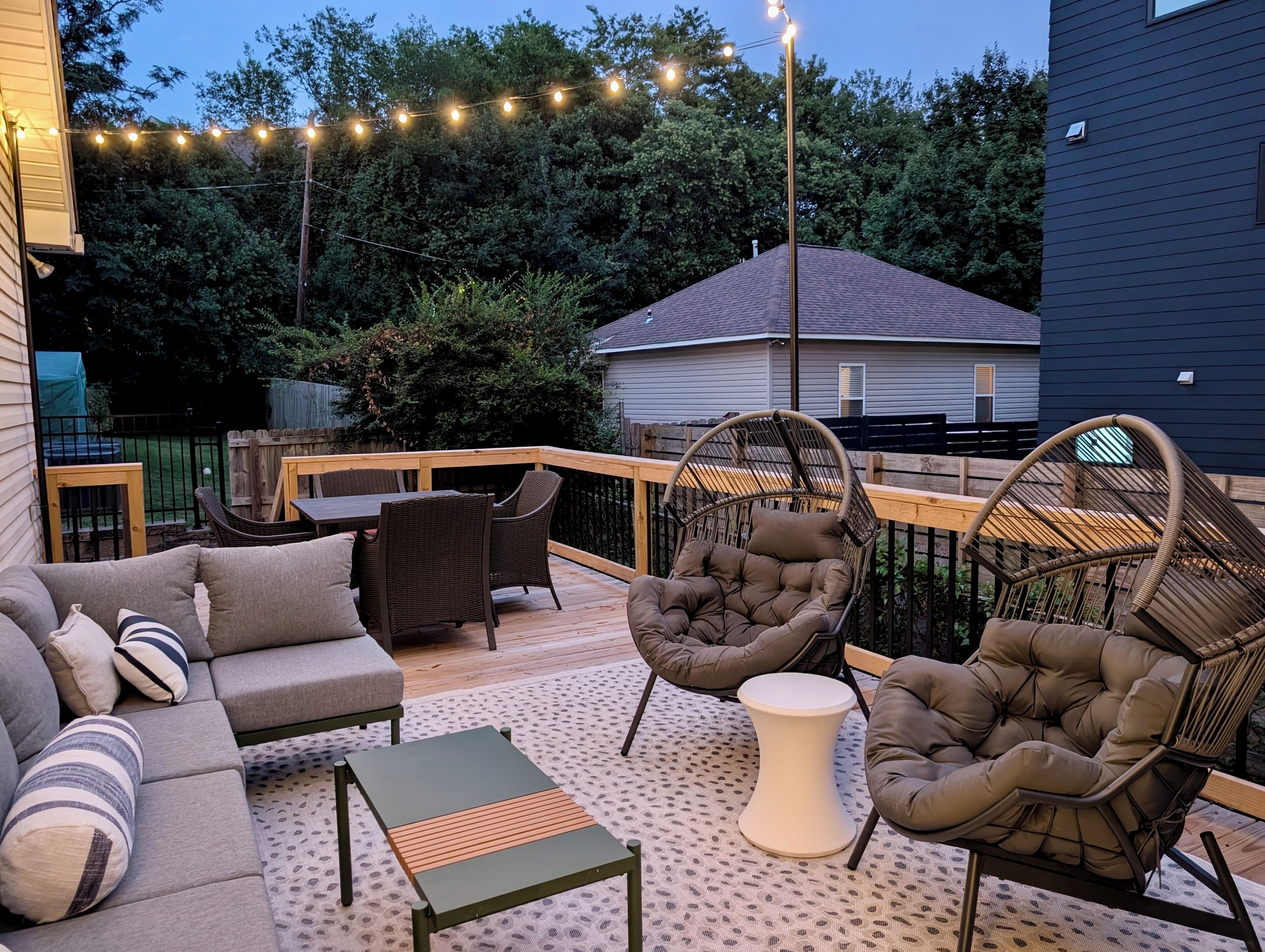 Eine Außenpatio mit einer Couch, Stühlen und einem kleinen Tisch.