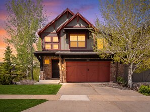A two-story house with a stone facade, a red garage door, and a well-maintained lawn. - Mins to Park City & Deer Valley! 4BR Townhome (Hideout)