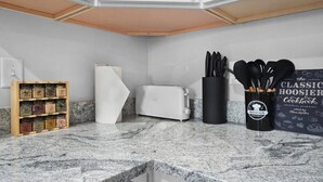 A kitchen with a granite countertop, a toaster, a spice rack, and a cookbook. - Luxe Downtown Townhome-Sleeps 6 Brand New Build! (Indianapolis)
