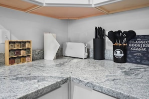 A kitchen with a granite countertop, a toaster, a spice rack, and a cookbook. - Luxe Downtown Townhome-Sleeps 6 Brand New Build! (Indianapolis)