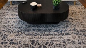 Un salón con sofá, una mesa de centro y una obra de arte en la pared.