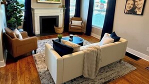 Una sala de estar con chimenea, un sofá, una mesa de centro y un ventanal grande.