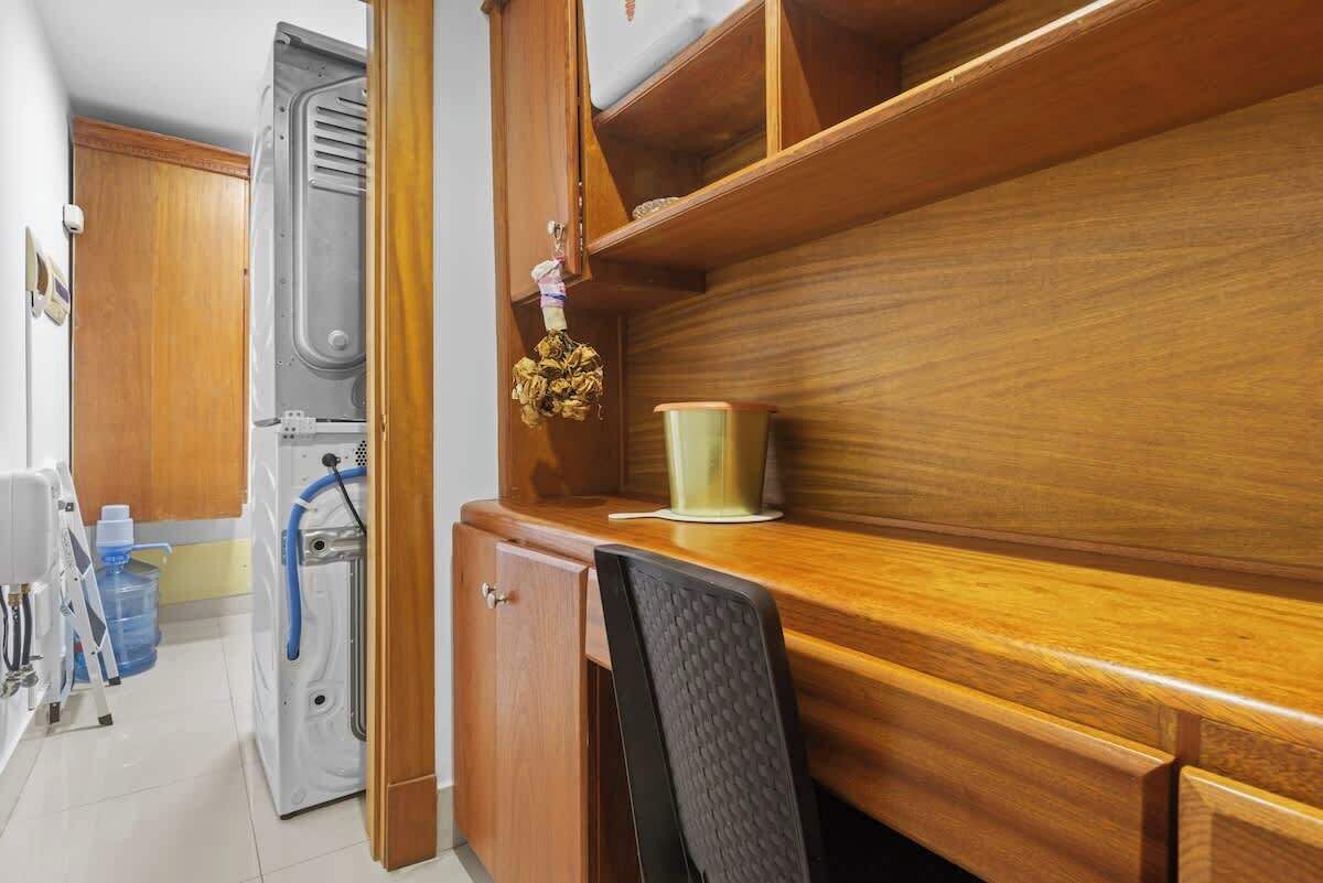 Une cuisine compacte avec des meubles en bois, un four à micro-ondes encastré et un petit évier.