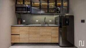 Een moderne keuken met een ingebouwde magnetron, een koelkast en een spoelbak.
