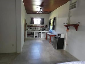 A kitchen with a ceiling fan, a microwave, and a small table. - Cabañas Paolone Popoyo 1, air conditioning, pool (Tola)