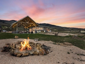 Un edificio con un espacio al aire libre techado, una chimenea y un paisaje montañoso al fondo.