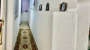 Ein Korridor mit Teppichmuster, einer Treppe und Wanddekorationen.