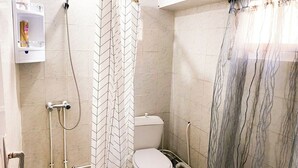 Ein Badezimmer mit Dusche, Toilette und Handtuchhalter.
