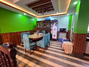 Un comedor con una mesa y sillas de madera, un refrigerador y un microondas.