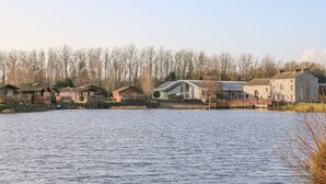 A lakeside property with multiple cabins, a large stone building, and a dock. - Hedgehog Lodge (Carnforth)
