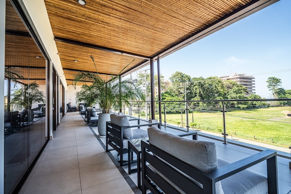Un espacio interior moderno con techo de madera, ventanas amplias y vistas al exterior.