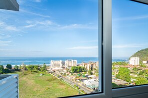 A coastal cityscape with buildings, a clear sky, and the ocean. - Ocean View Condo Steps to Beach & Comfort (Jacó)