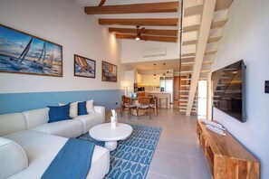 A modern living room with a sofa, coffee table, and artwork on the walls. - Spectacular Golf PH with private rooftop (Punta Cana)