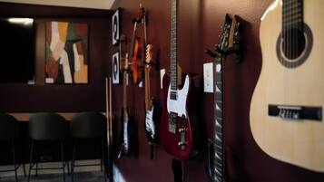 Un mur orné de différentes guitares et d’un tableau.