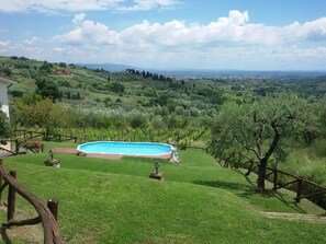 A swimming pool surrounded by a well-maintained lawn, with a view of distant hills and a clear sky. - Ciclamino House: Pool, view, wifi, lucca, Tuscany (San Gennaro)
