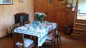 A dining area with a table set for four, wooden walls, a chandelier, and a staircase in the background. - Ciclamino House: Pool, view, wifi, lucca, Tuscany (San Gennaro)