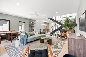 A spacious living area with a sofa, coffee table, and seating arrangements. - The Lightwell- Garage - 0.5 mi DT (Bentonville)