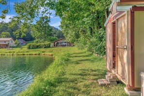 Ein Seeufergrundstück mit einer Holzhütte, einem kleinen Schuppen und einem Haus.