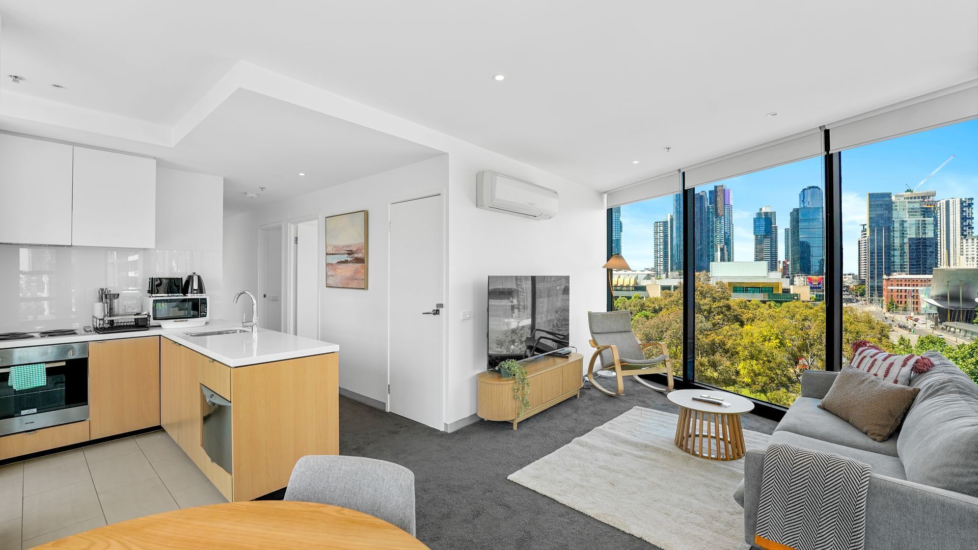 Un apartamento moderno con cocina, comedor y sala de estar con vista a la ciudad.