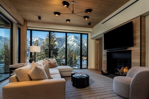 A modern living room with a large TV, fireplace, and a sofa. - Modern Luxury in Downtown Ketchum (Ketchum)