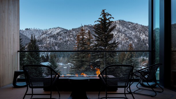 A modern interior with a large glass window overlooking a snowy mountain landscape. - Modern Luxury in Downtown Ketchum (Ketchum)