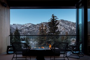 A modern interior with a large glass window overlooking a snowy mountain landscape. - Modern Luxury in Downtown Ketchum (Ketchum)