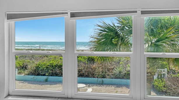 A bay window with a view of the ocean and tropical plants. - INCREDIBLE! Oceanfront Dream Escape! Unit 21 is a Rare 3-Bedroom Condo! (Cocoa Beach)