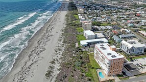 An aerial view of a coastal area with a beach, buildings, and a large hotel with a pool. - INCREDIBLE! Oceanfront Dream Escape! Unit 21 is a Rare 3-Bedroom Condo! (Cocoa Beach)