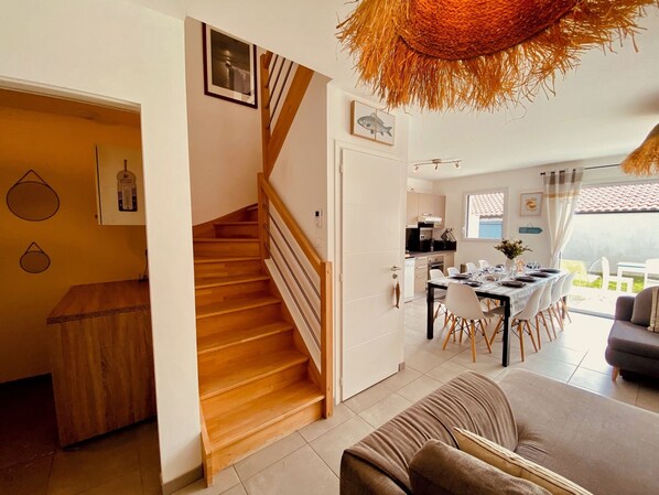 Ein modernes Interieur mit Treppe, Essbereich und Wohnbereich.
