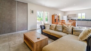 A modern living room with a sofa, coffee table, and dining area with chairs and a table. - Holiday Home 'Les Cinsault' with Private Pool, Wi-Fi and Air Conditioning (Vaison-la-Romaine)