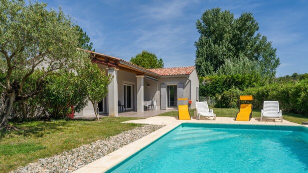 A swimming pool with a tiled deck, surrounded by a grassy area and trees. - Holiday Home 'Les Cinsault' with Private Pool, Wi-Fi and Air Conditioning (Vaison-la-Romaine)