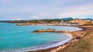 Une vue côtière avec un rivage rocheux, des bâtiments et des bateaux.