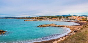 Une vue côtière avec un rivage rocheux, des bâtiments et des bateaux.