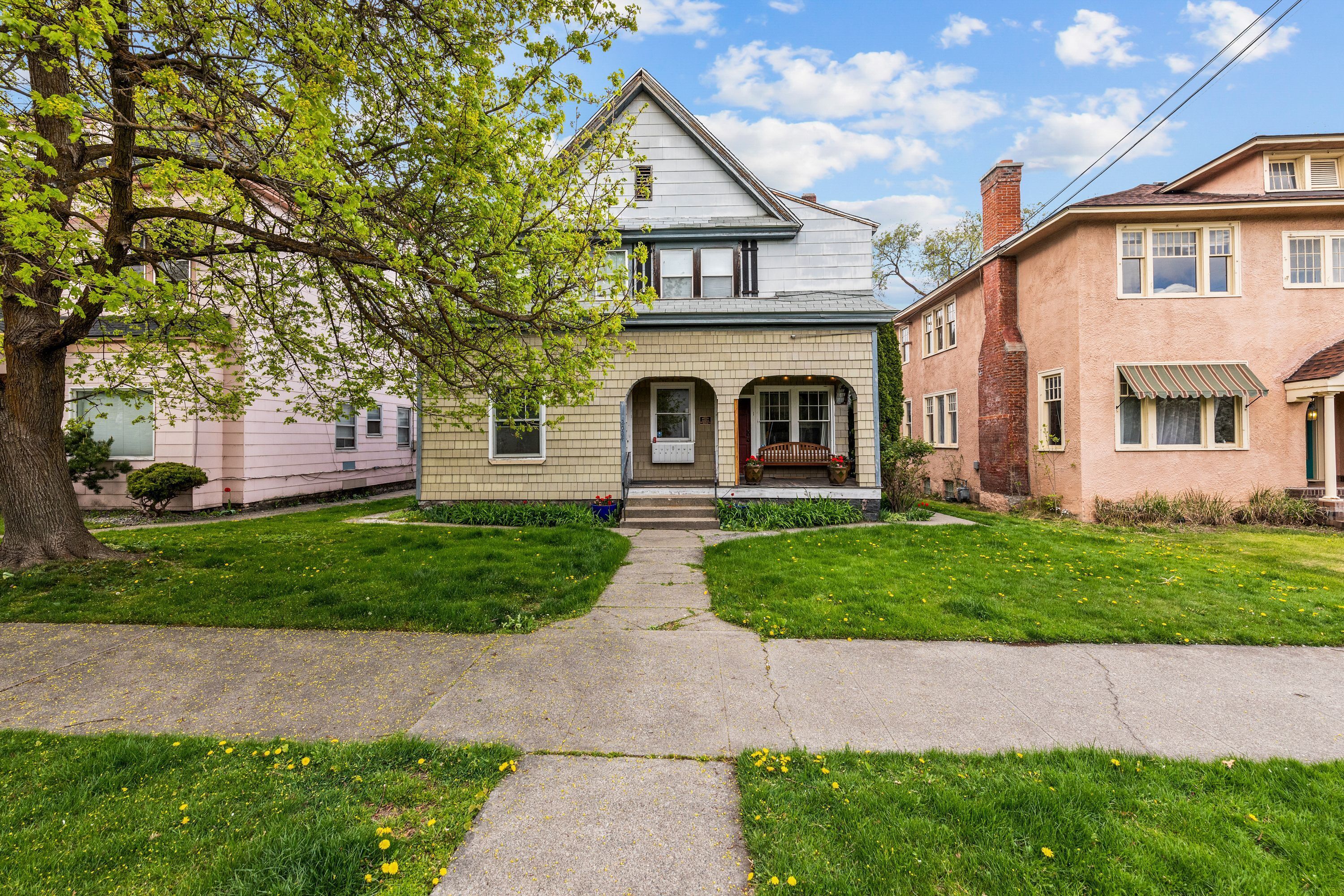 A two-story house with a front porch, a visible chimney, and a well-maintained lawn.