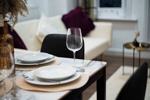 A dining table with plates, a wine glass, and a vase. - New Modern Apartment with 55"TV Next to Station (London)