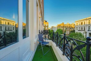 A balcony with a chair, a railing, and a view of neighboring buildings. - New Modern Apartment with 55"TV Next to Station (London)