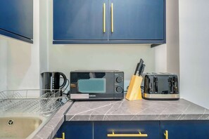 A kitchen with a coffee maker, toaster, and knife block on the counter. - New Modern Apartment with 55"TV Next to Station (London)